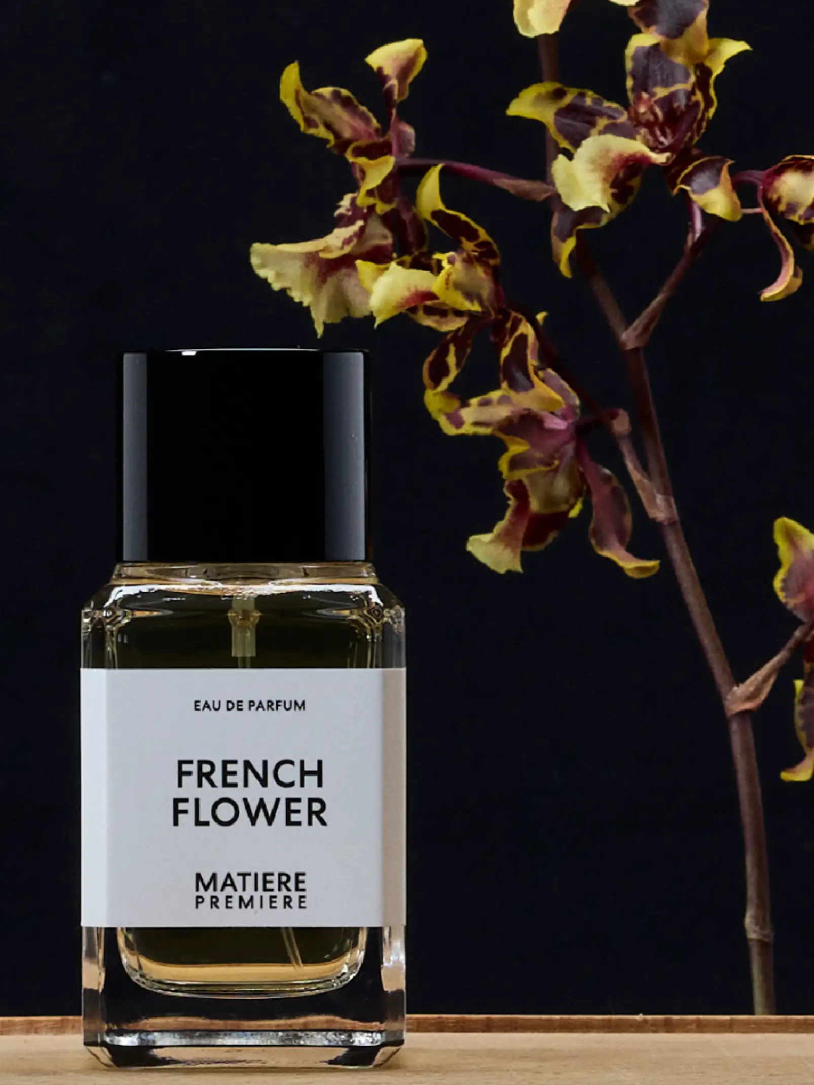 Perfume French Flower con orquídeas de fondo para campaña de fragancias de lujo con estética botánica.