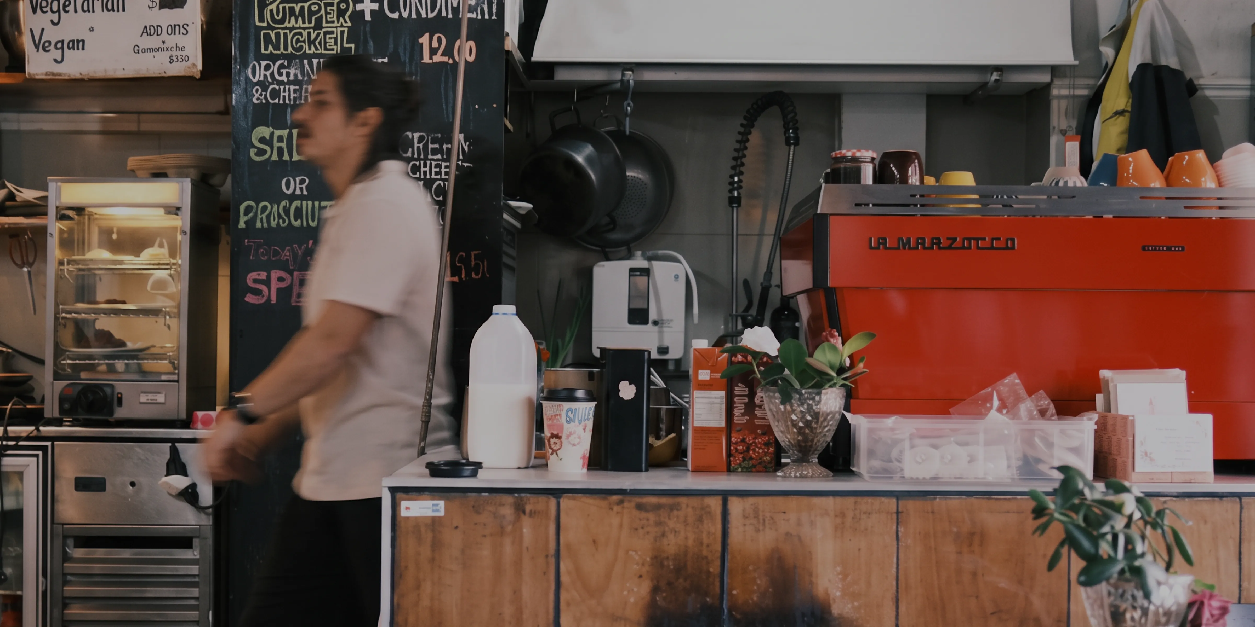 A barista walking past the espresso station inside Coffee Creative coffee shop