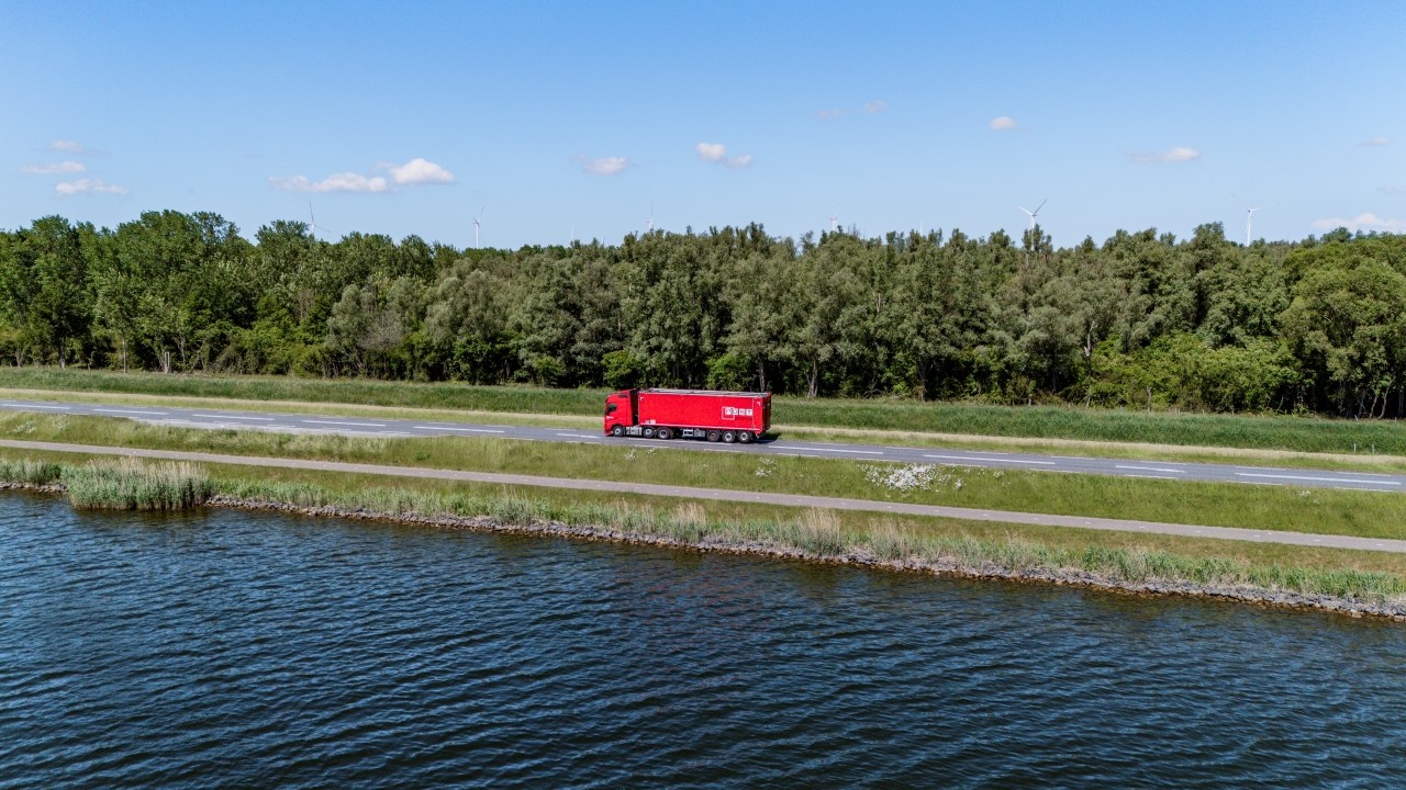 Rode vrachtwagen van Post Handel en Transport op een weg in de polder