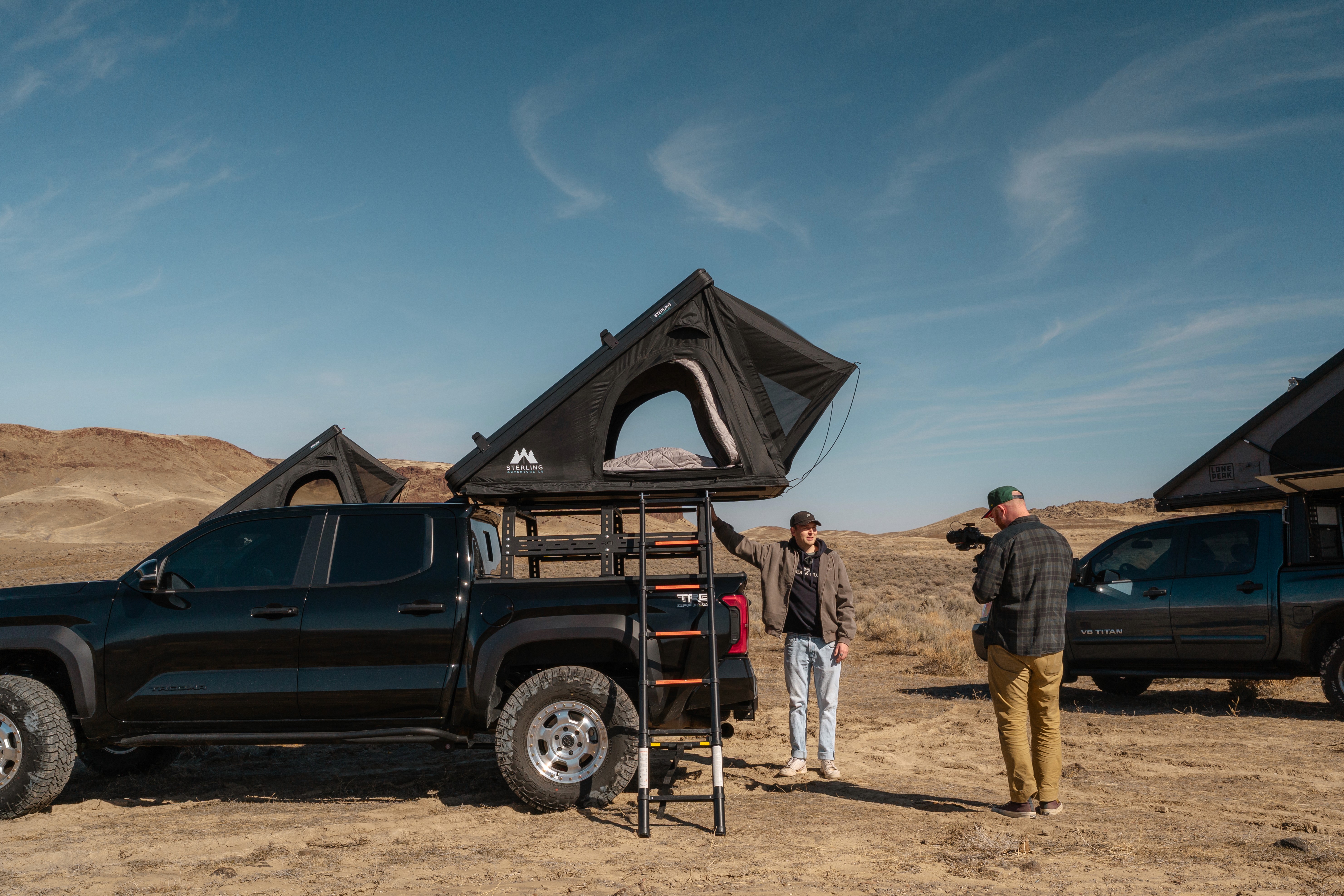 Black and white photo of two people looking at a computer screen with papers on wall