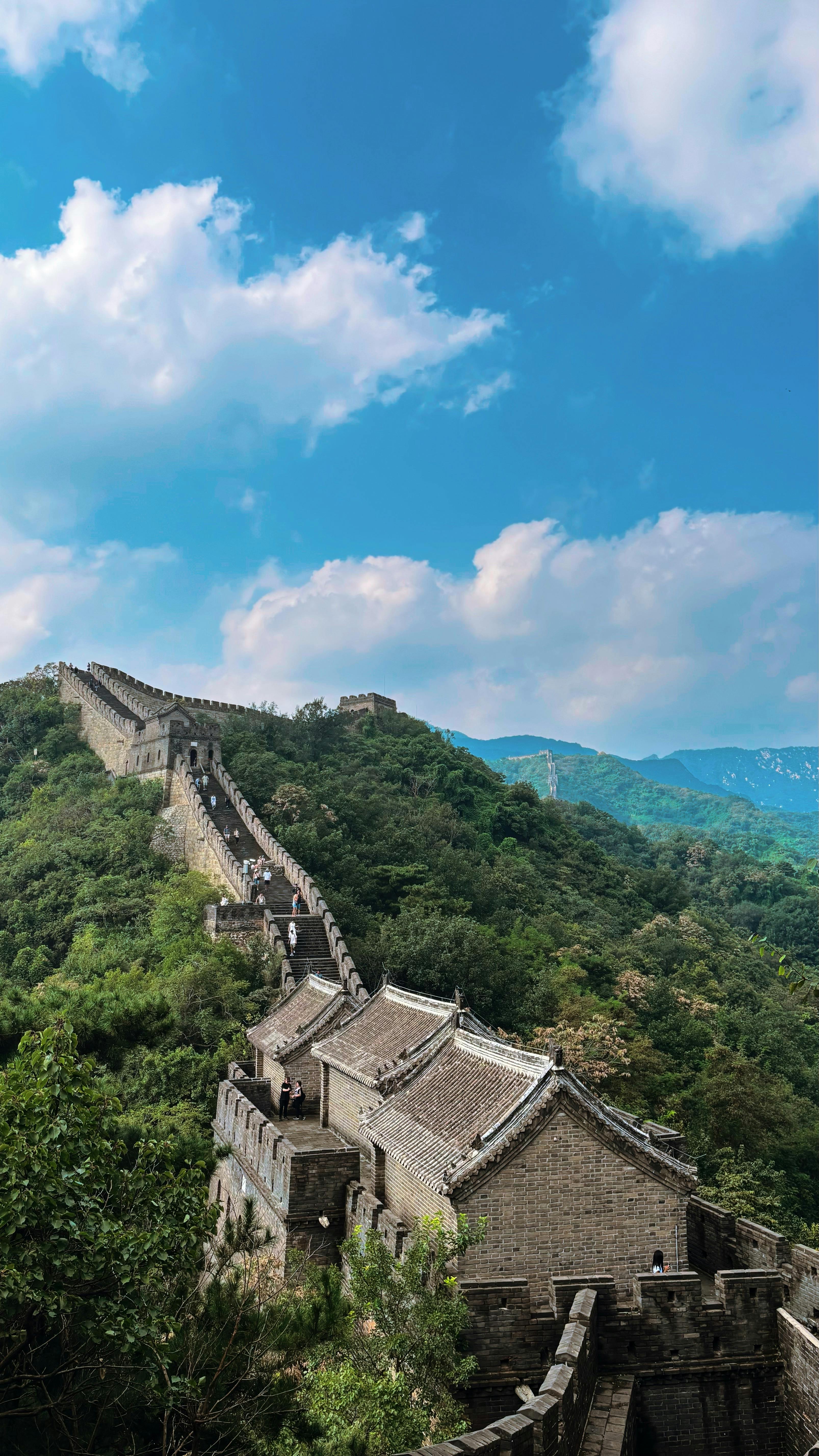 The Great Wall of China winding through green mountains