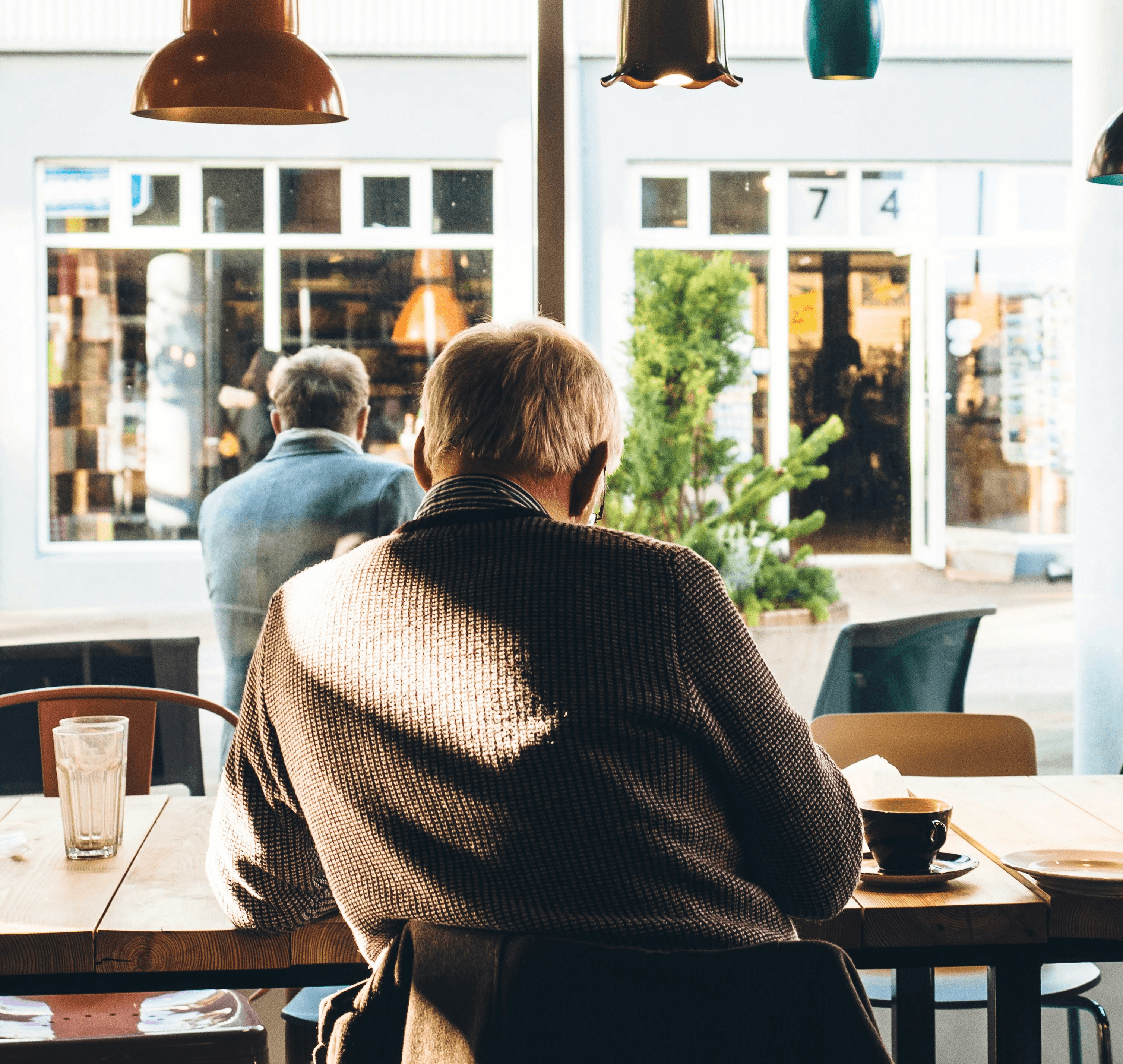 Back of elderly man at table