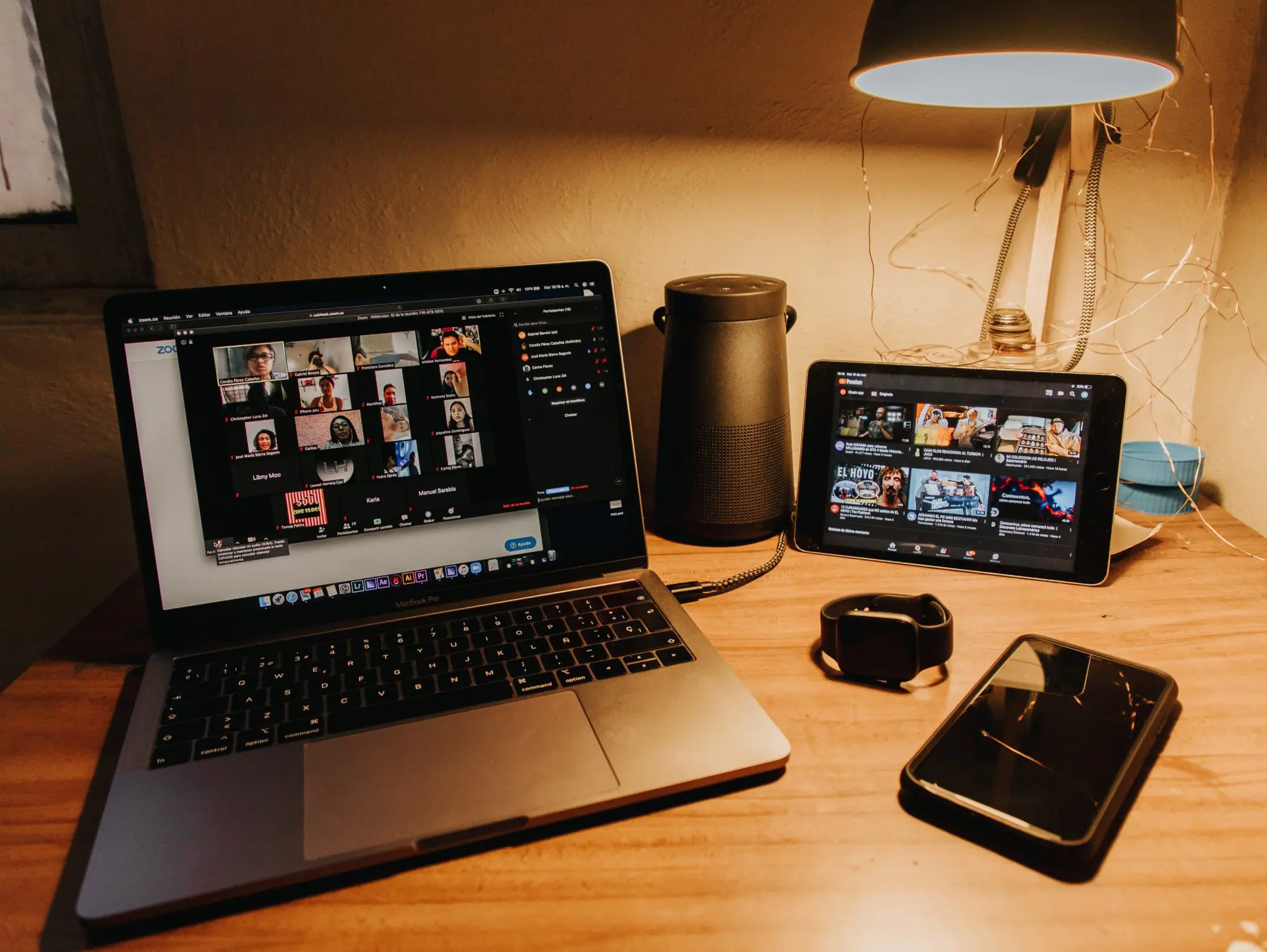 Laptop and tablet on a table displaying a live online class in session