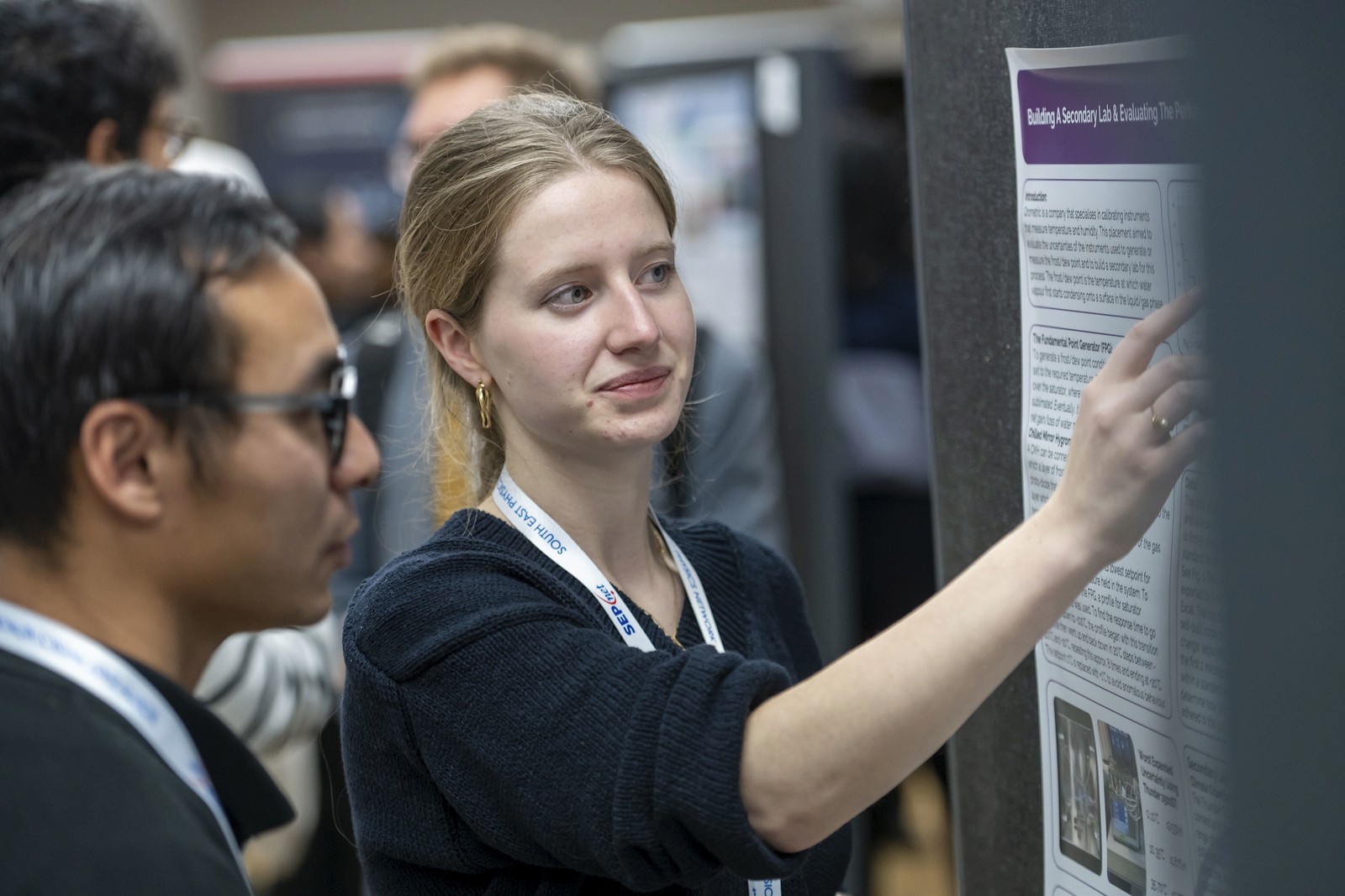 RHUL student explaining their poster to a fellow student