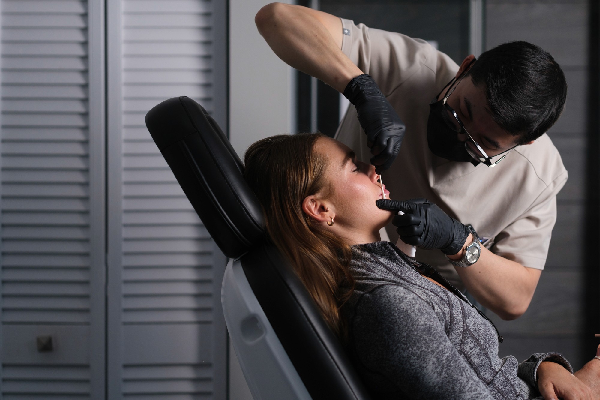 Patient lying down receiving treatment from Dr. Alex Nguyen