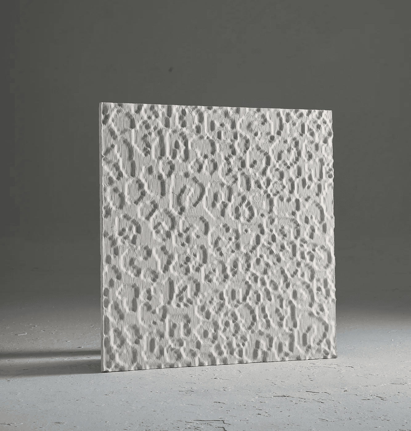 Carved marble surface study inspired by the irregular spotted rhythm of leopard skin, translated into an abstract tactile relief.