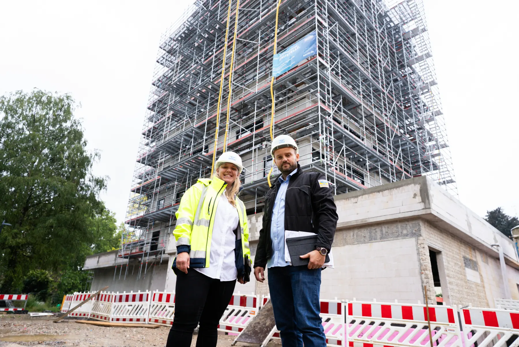 Das Team mit Warnweste und Helmen auf der Baustelle