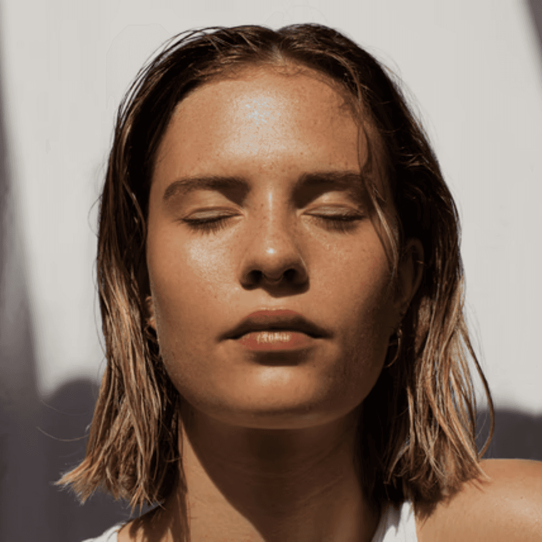 A woman with short hair, eyes closed, exuding a sense of calm and serenity.