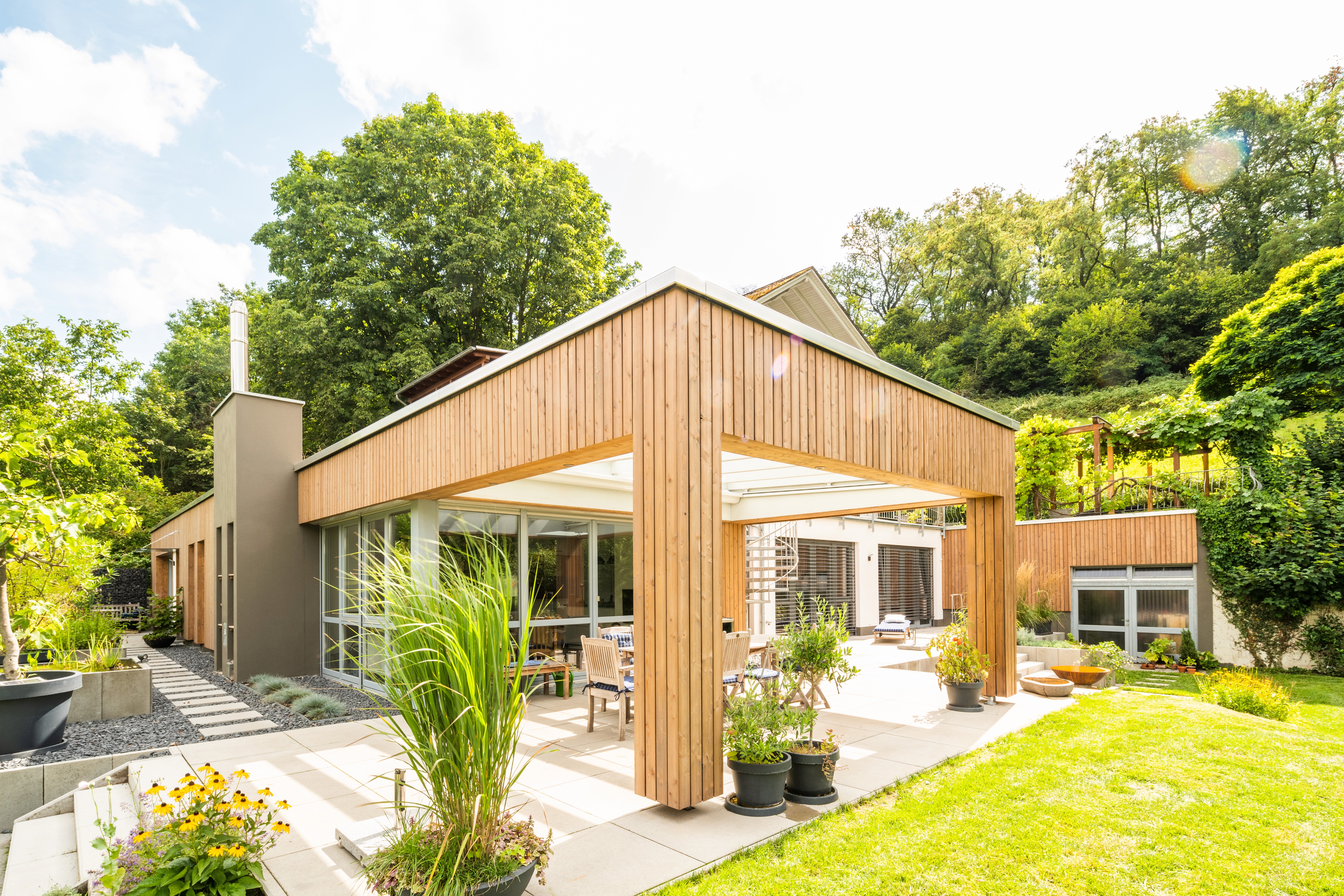 Holzanbau für die Terasse in einem grünen Garten