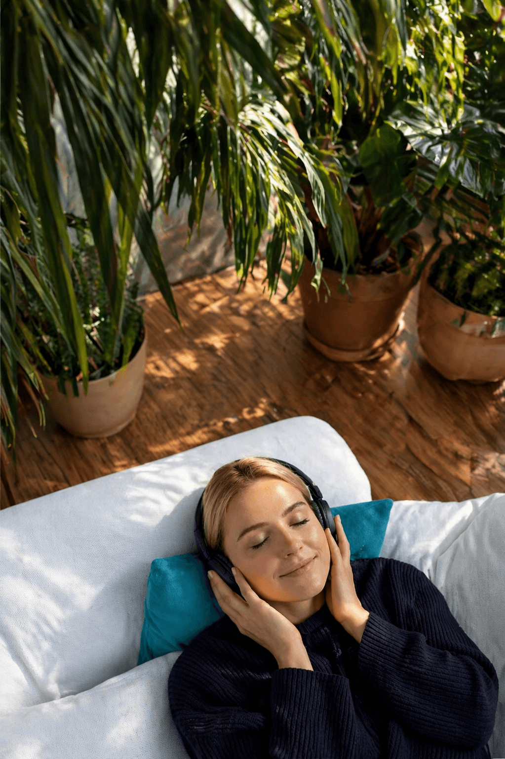 Lady laying down under the Sun, wearing headphones and enjoying Clarity's focus mode.