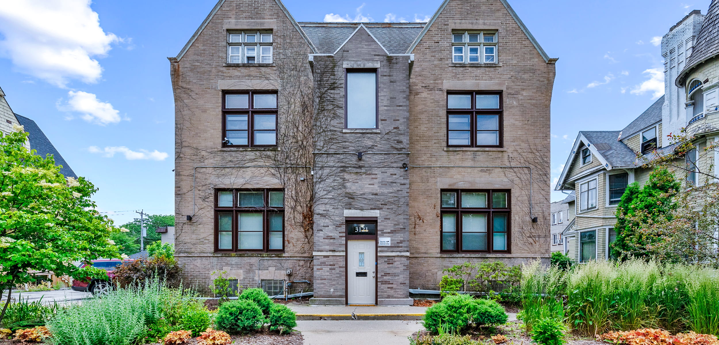 A stone mansion with lush green garden