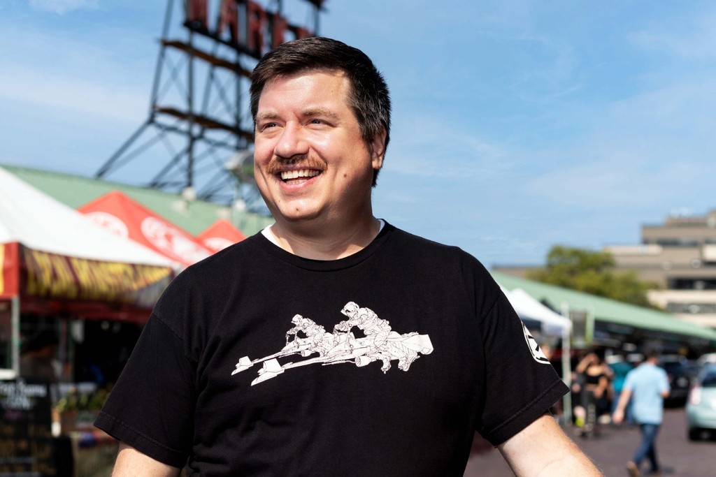 Austen standing in front of the Pike Place Public Market sign.
