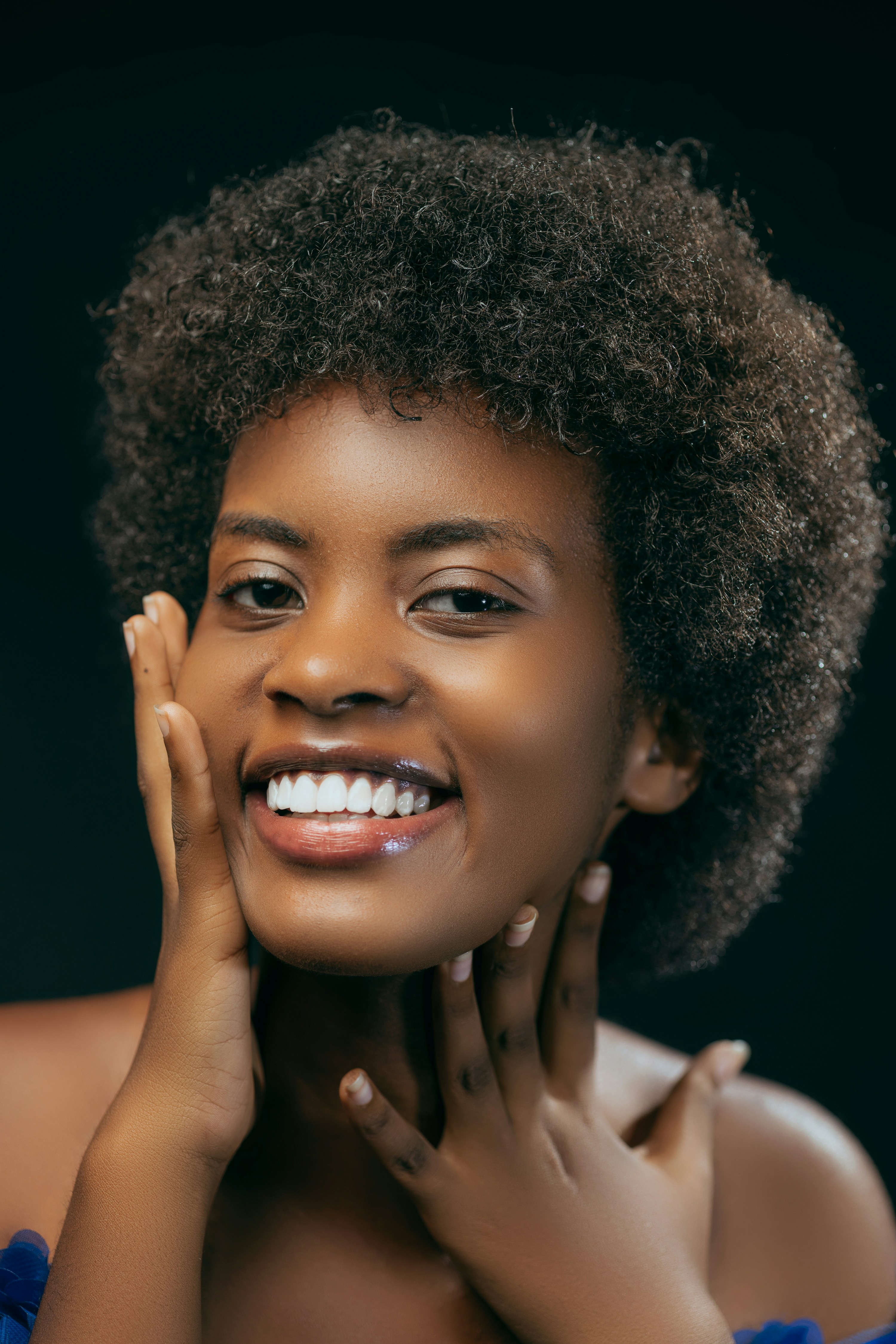 a woman with an afro is smiling for the camera