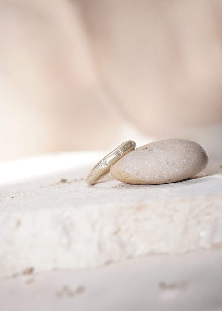 Silver ring with engraved sparks on a stone with a soft, blurred background