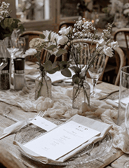 Edle Tischdekoration für eine Hochzeit in Weiß- und Naturtönen mit Blumen und Geschirr