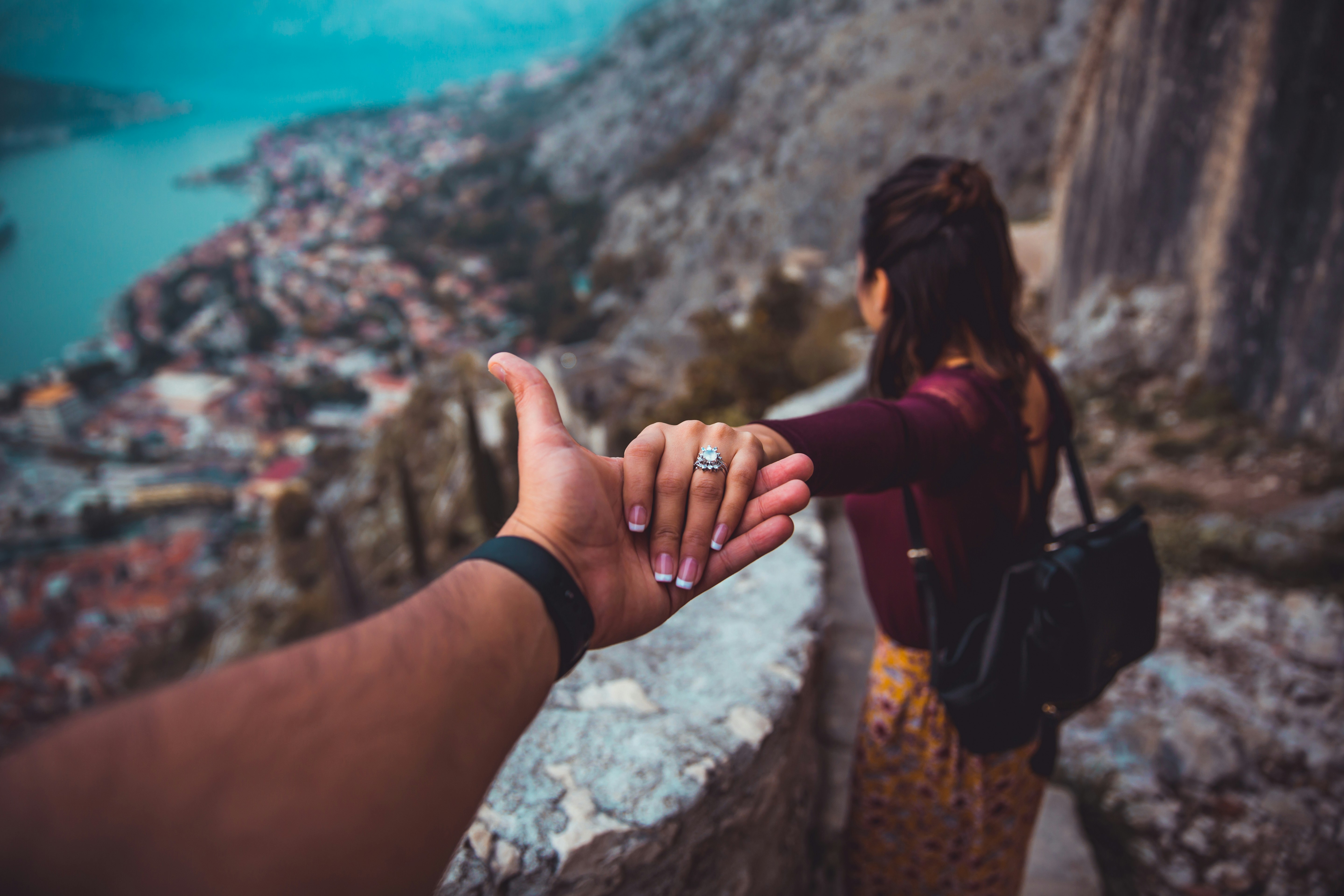 Couple reaching out and letting go of each other's hands, symbolising the pain of a breakup and the need for relationship counselling in Manchester