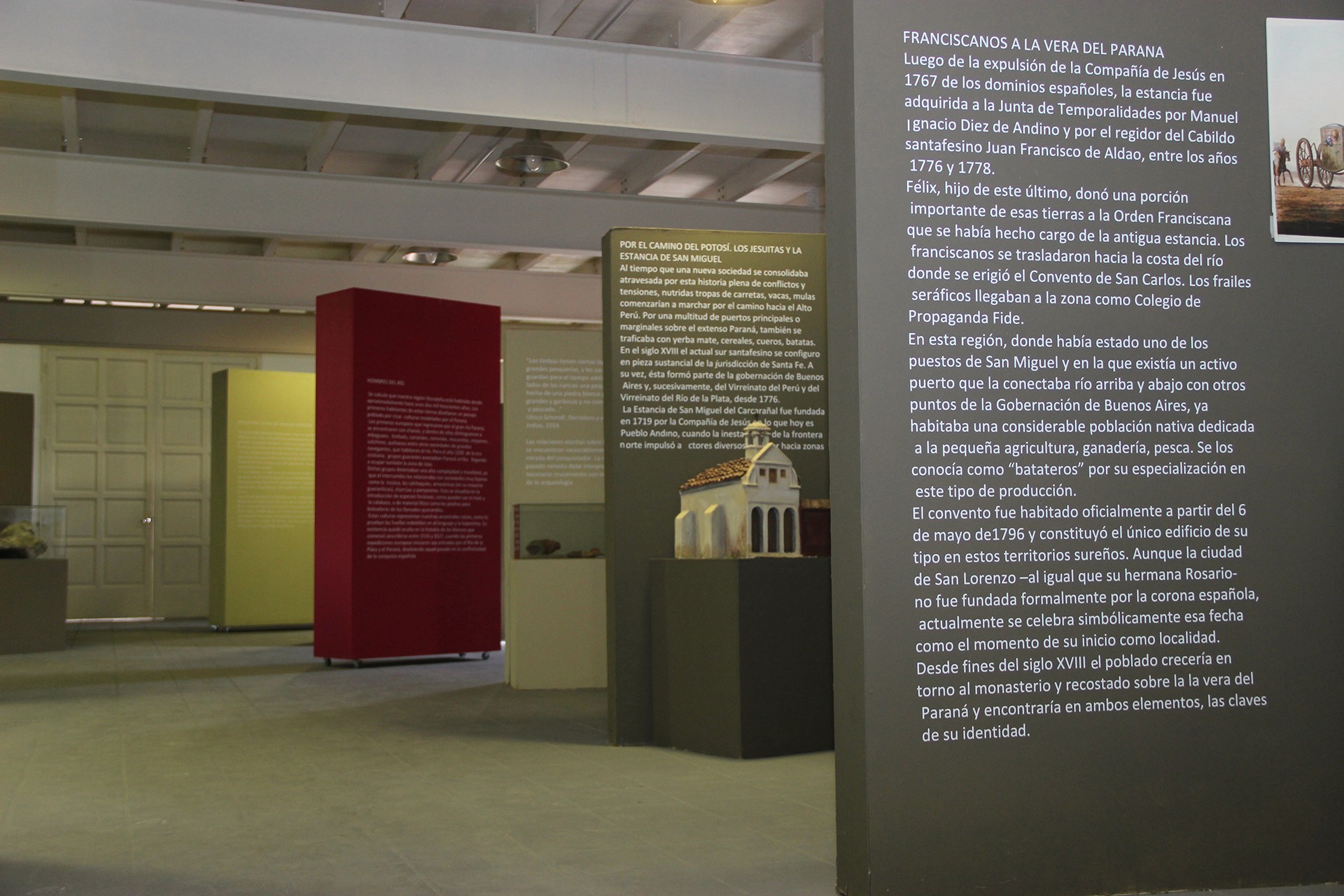 Black and white photo of two people looking at a computer screen with papers on wall