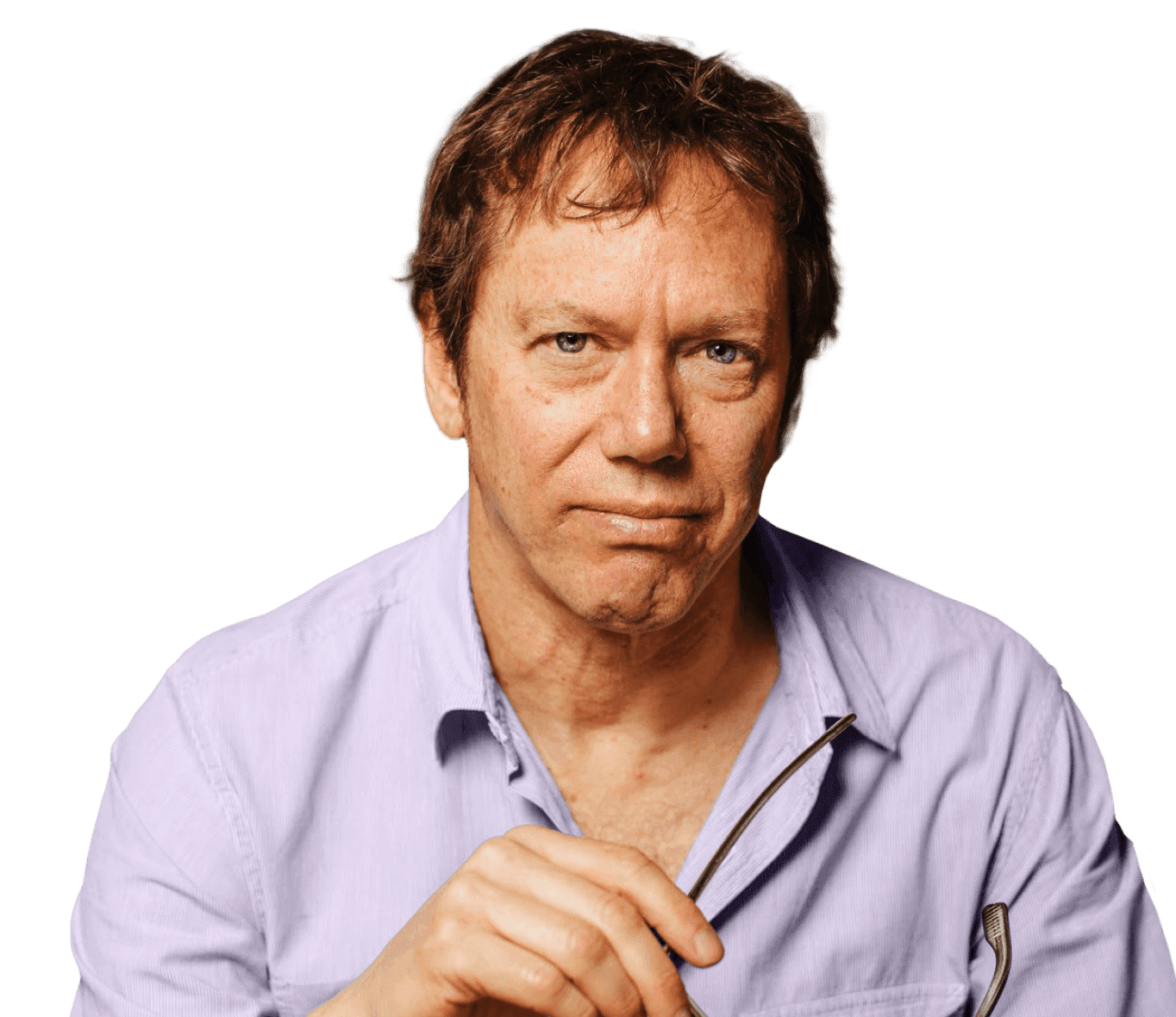 Smiling person with curly hair, wearing a black shirt, against a warm, dark background.