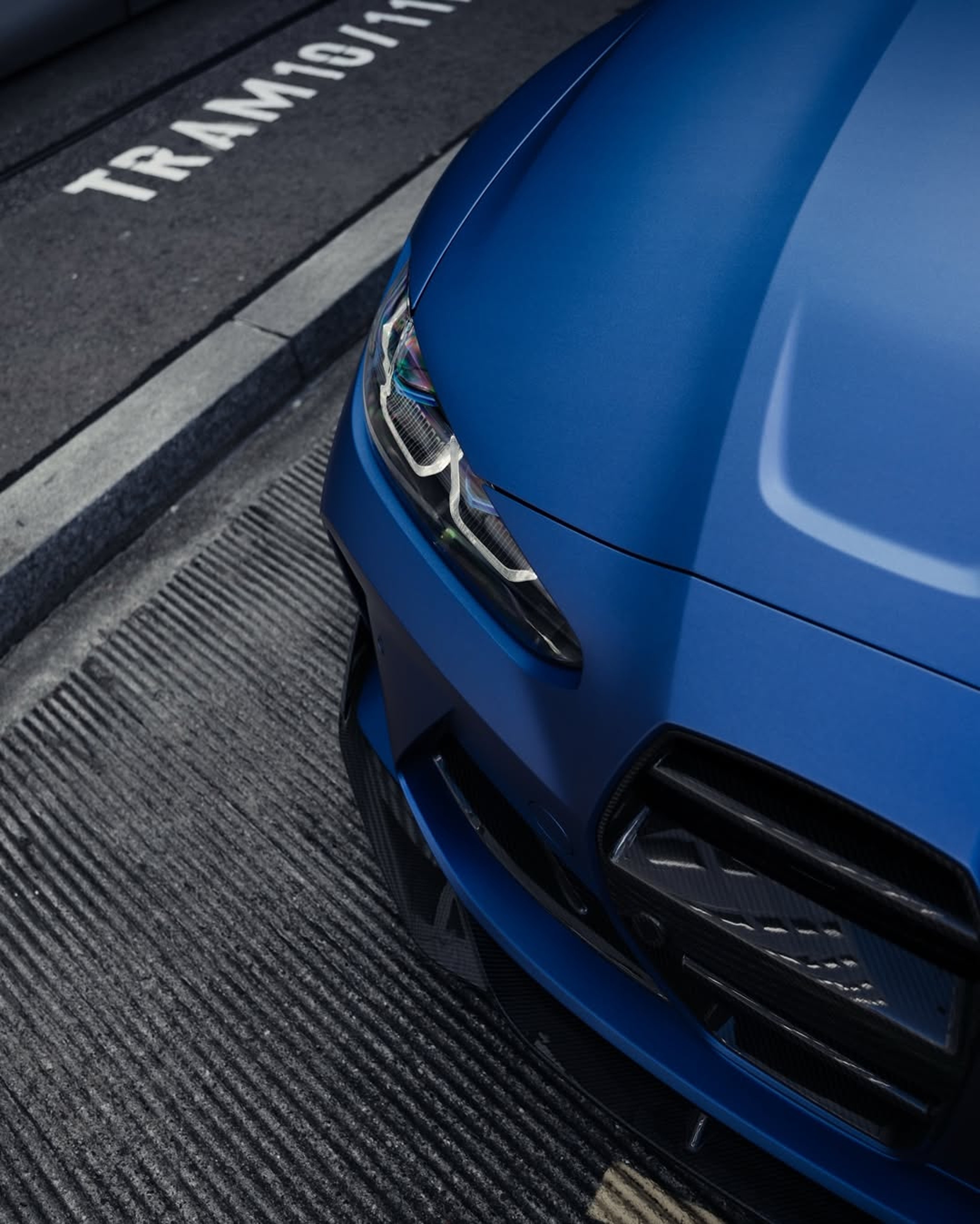 Face avant d’une BMW M3 bleue mate vue en plongée