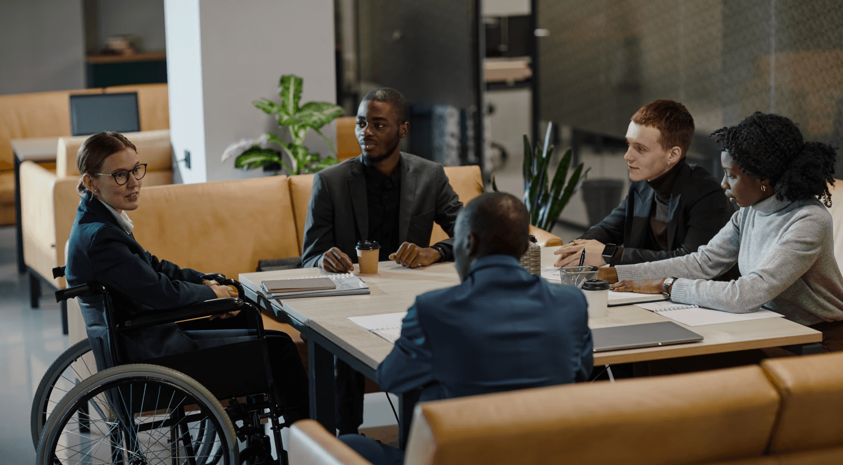 5 personnes en réunion dont une en fauteuil roulant