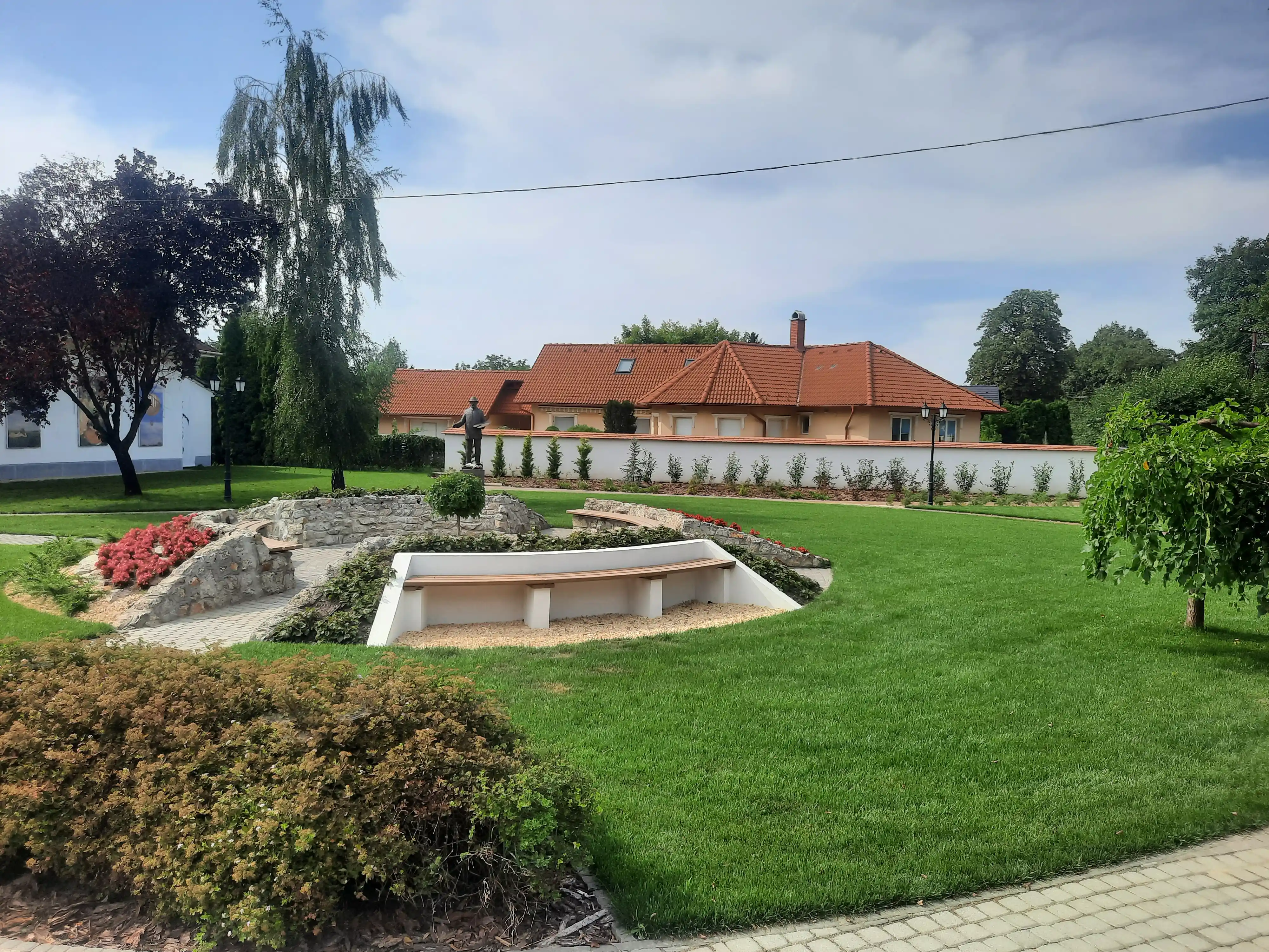 Közterület kialakítás pihenőpadokkal és díszgyeppel