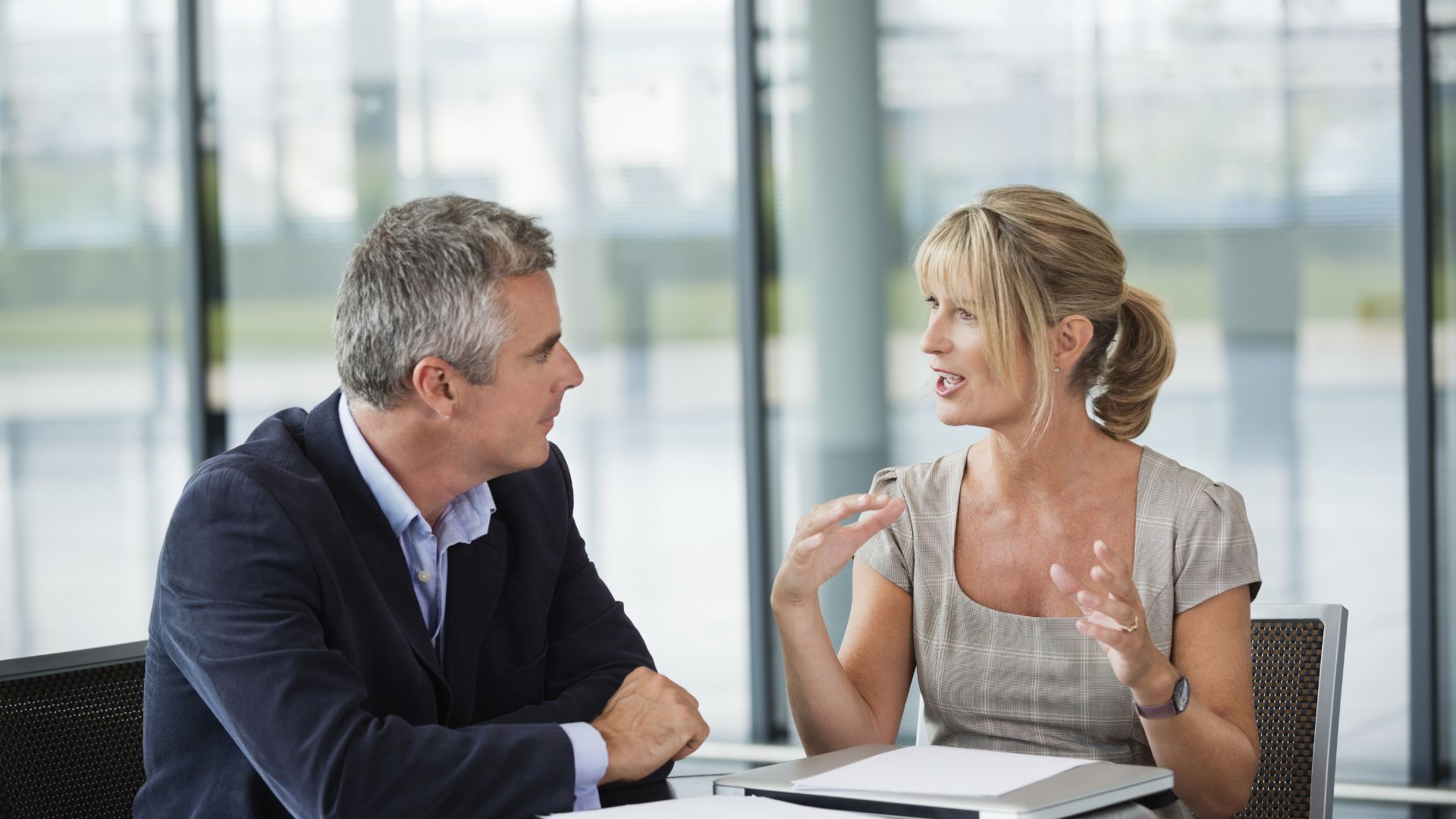 Two colleagues in deep conversation across a meeting table