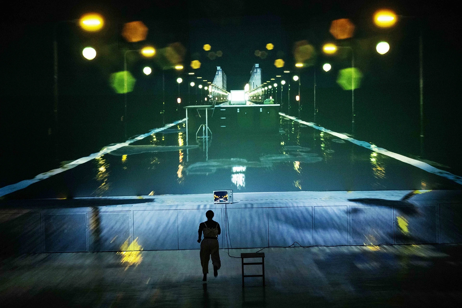 Person running on stage toward projection scene