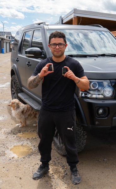 happy customer holding his newly made land rover keys