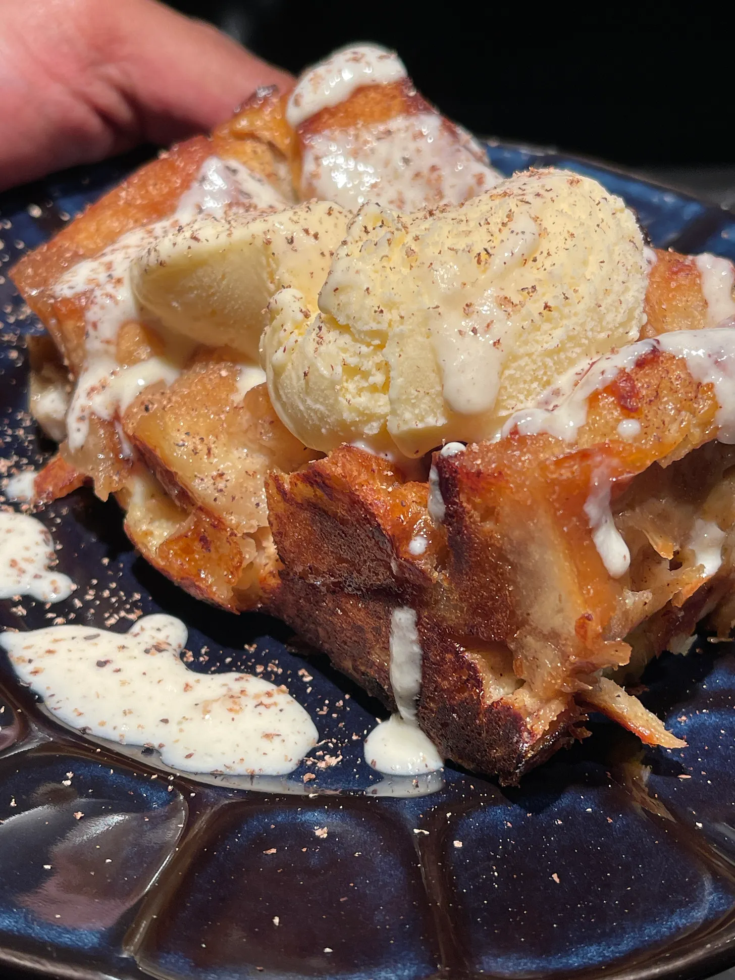 golden-brown, moist bread-pudding with vanilla ice cream melting over the top