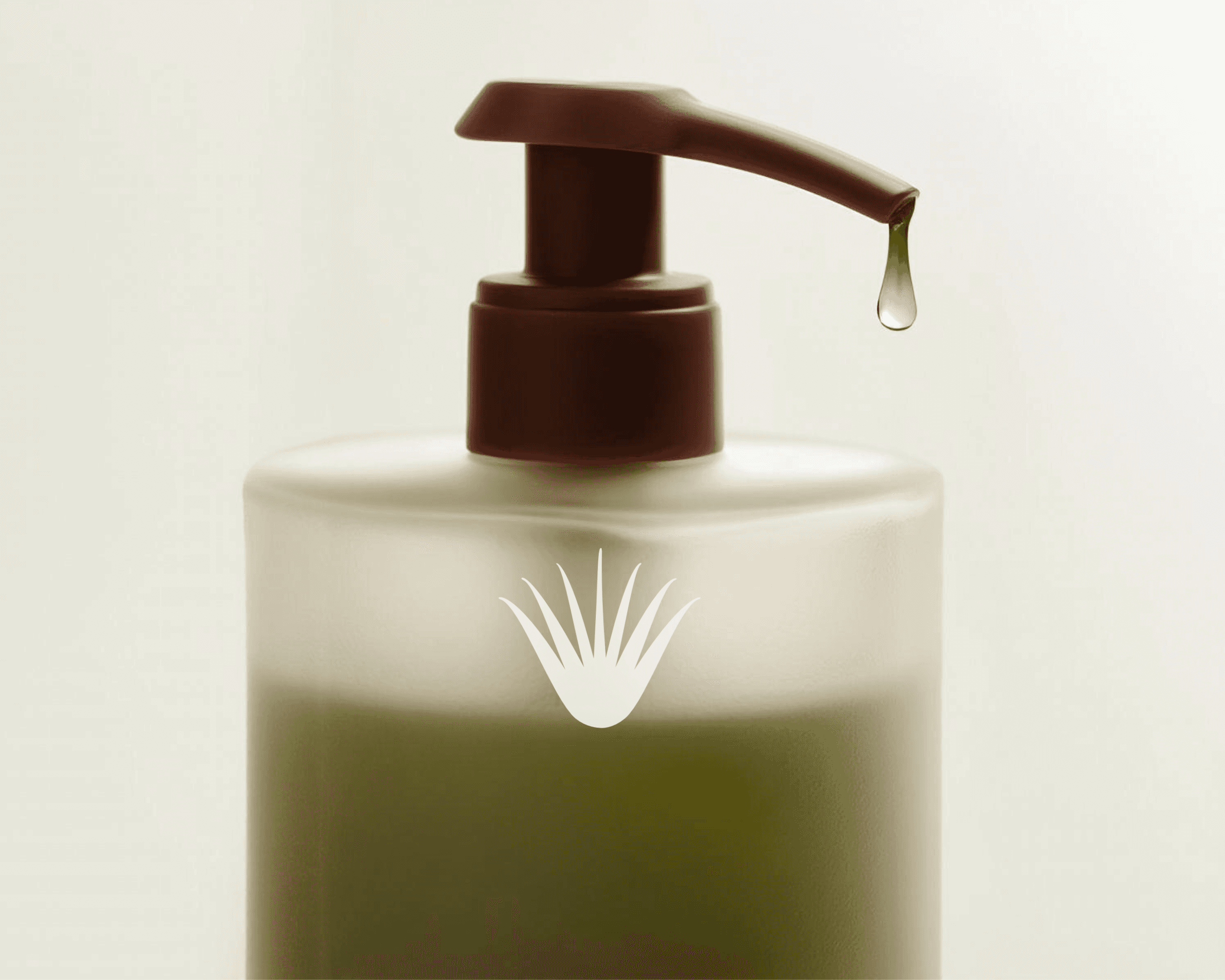 A closeup shot of a packaging bottle for the organic skincare brand VÉRA Botanicals. The bottle has a frosted glass finish with olive-green liquid inside it. A drop of product is dripping out of the pump nozzle.