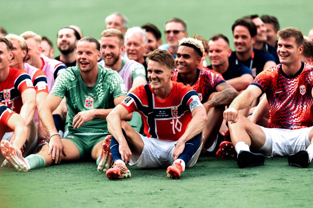 Martin Odegaard and Norway teammates smile in a pitch-side celebration photo after their win over Brazil
