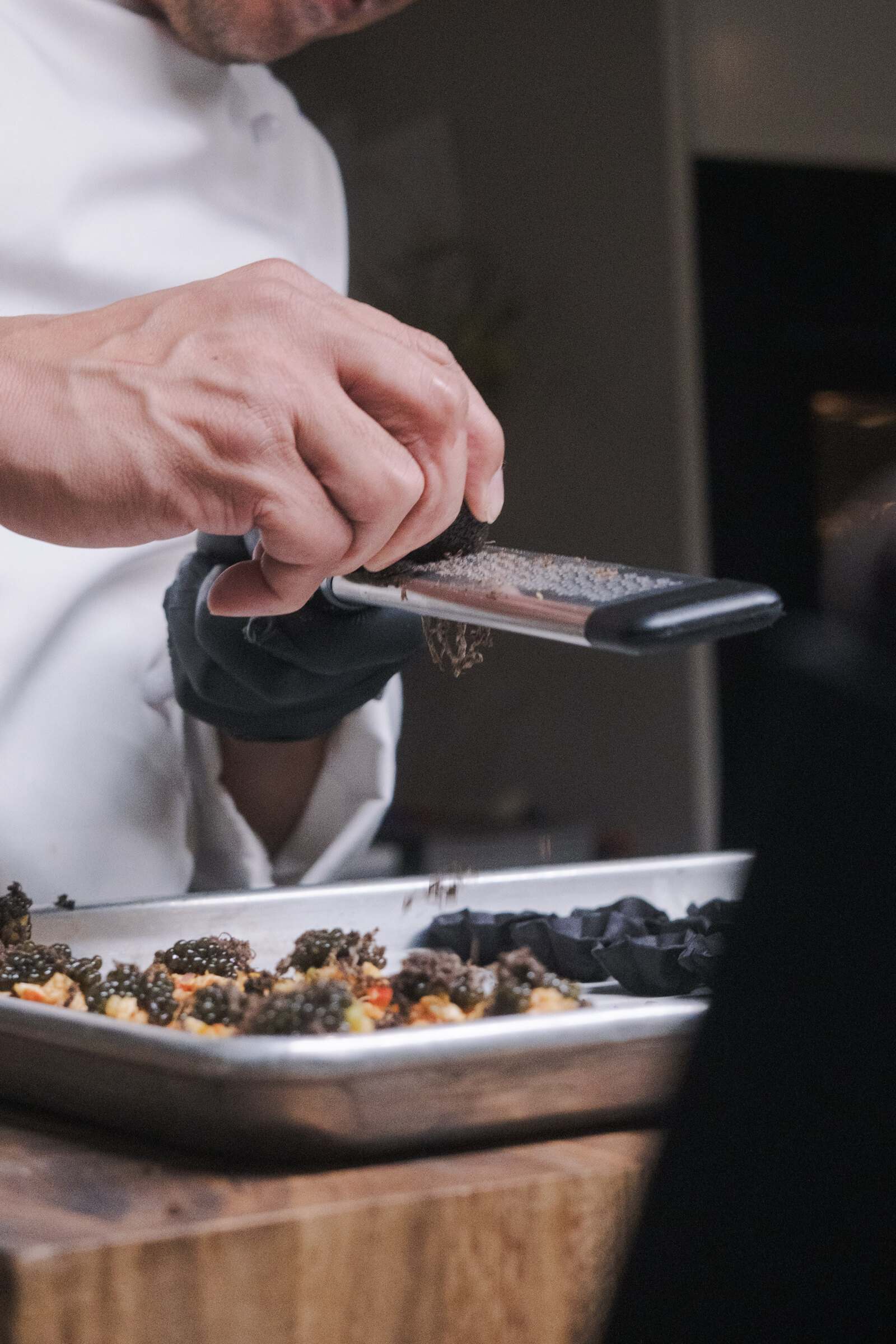Chef shaving truffle over canapés