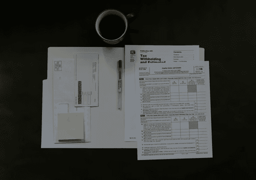 A collection of documents and a circular object arranged on a dark surface.