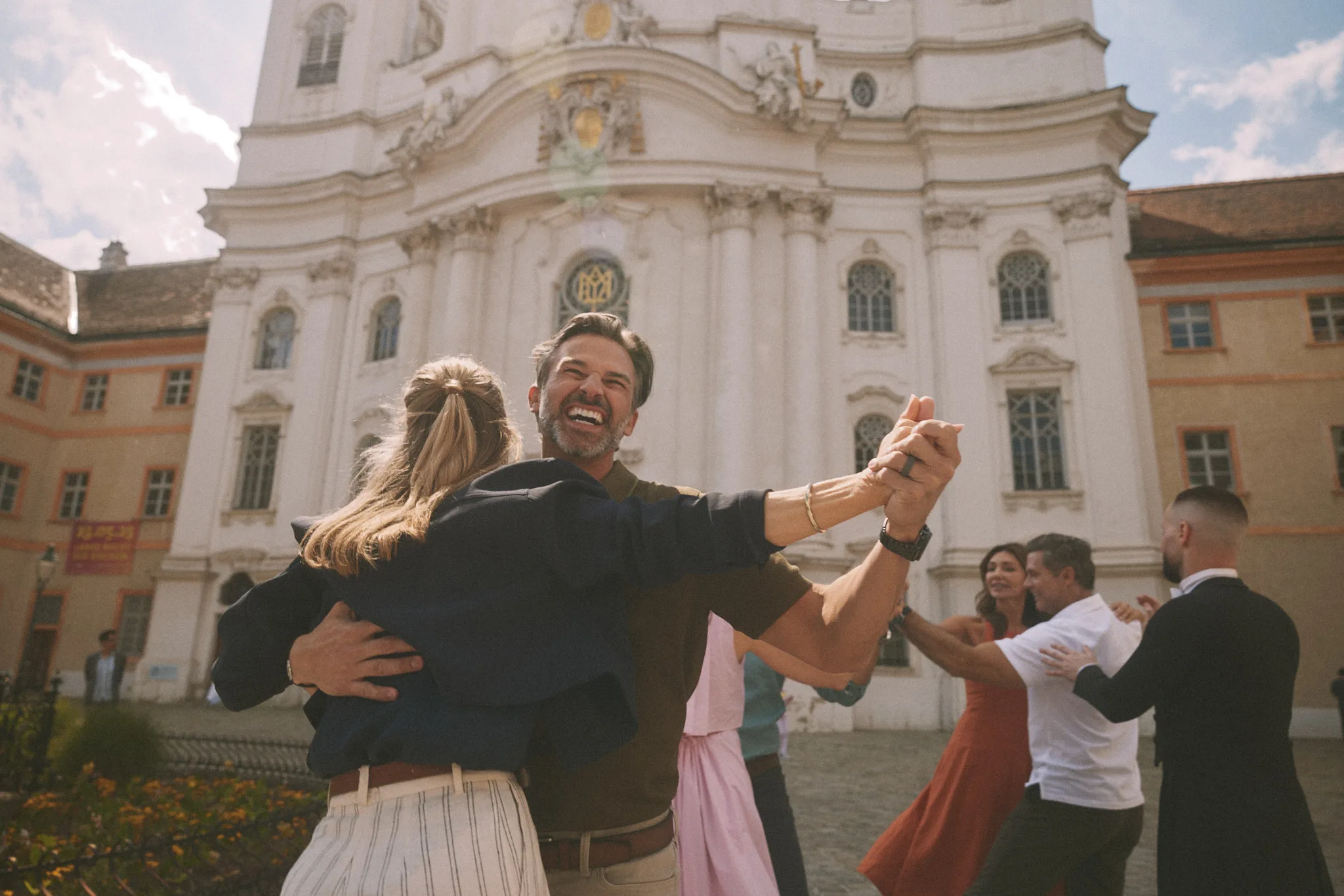couples dancing outside baroque church facade — lifestyle photography by Tom Kubik