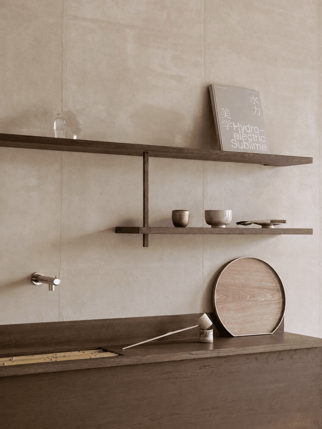 Dark wood shelves, ceramic vessels and a book in the calm interior of MIZUYA Japan.