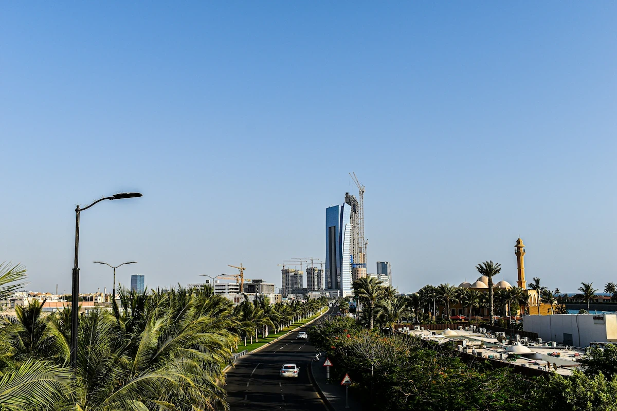 Jeddah Corniche roadway lined with palms leading toward the modern Jeddah skyline, Saudi Arabia.