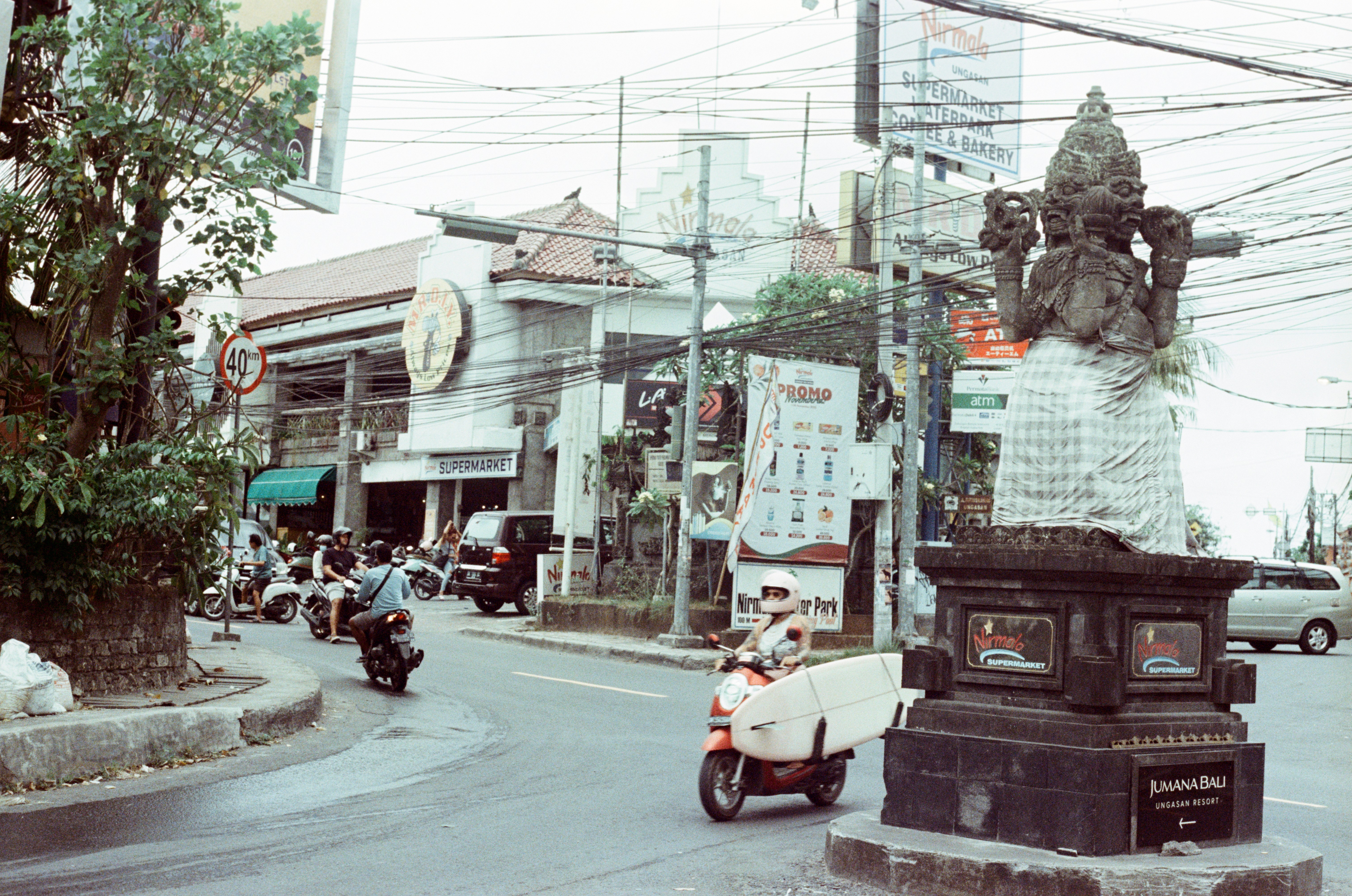 the surfer girl is driving with her surfboard in Bali