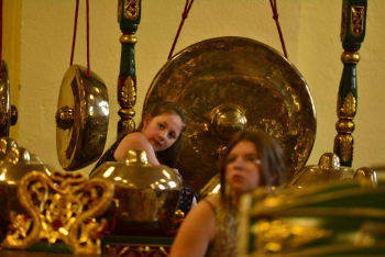 Des enfants sont devant un grand gong javanais.