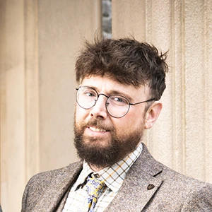 Ben Fox, male tour guide with beard and tweed smart jacket and tie