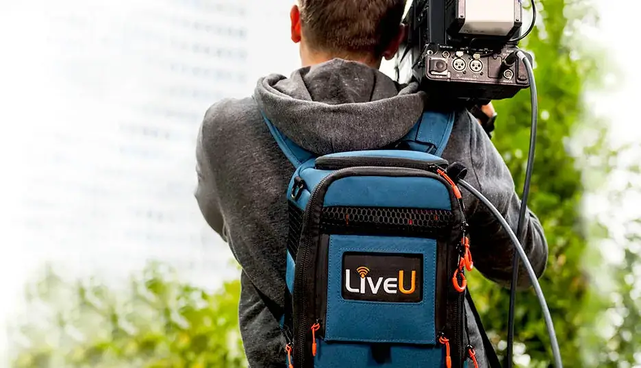 man in gray hoodie and blue denim jeans standing on brown wooden parquet flooring