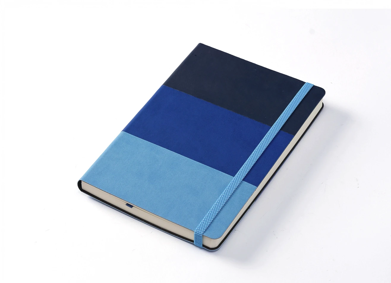Angled view of closed blue notebook secured by elastic strap.