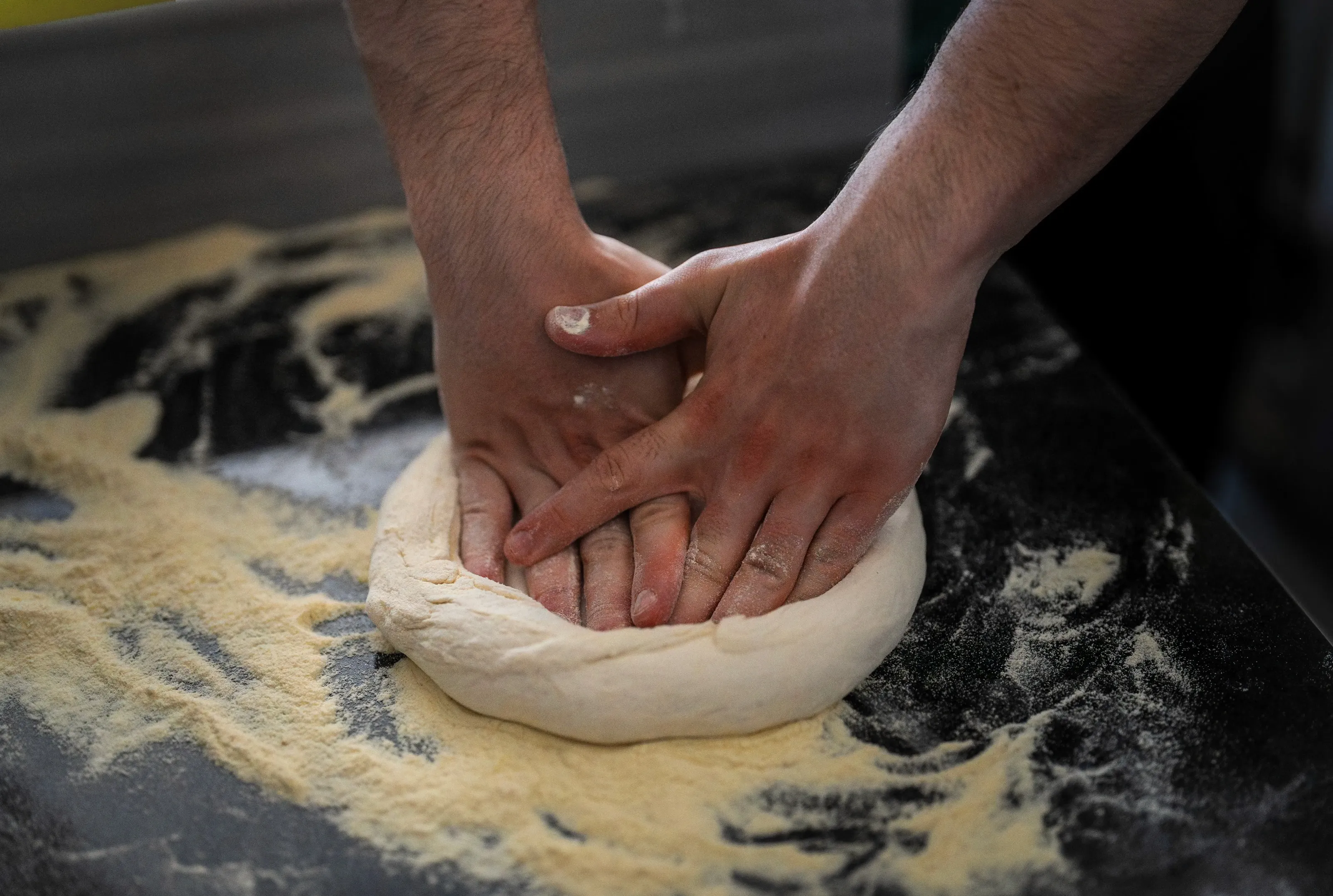 hands working the pizza dough