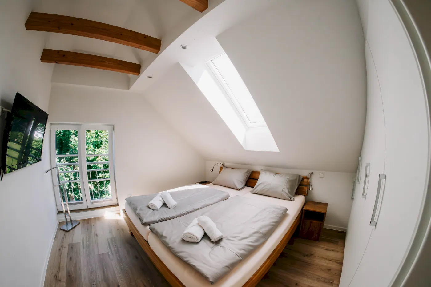 Schlafzimmer mit Bett und hoher Decke.