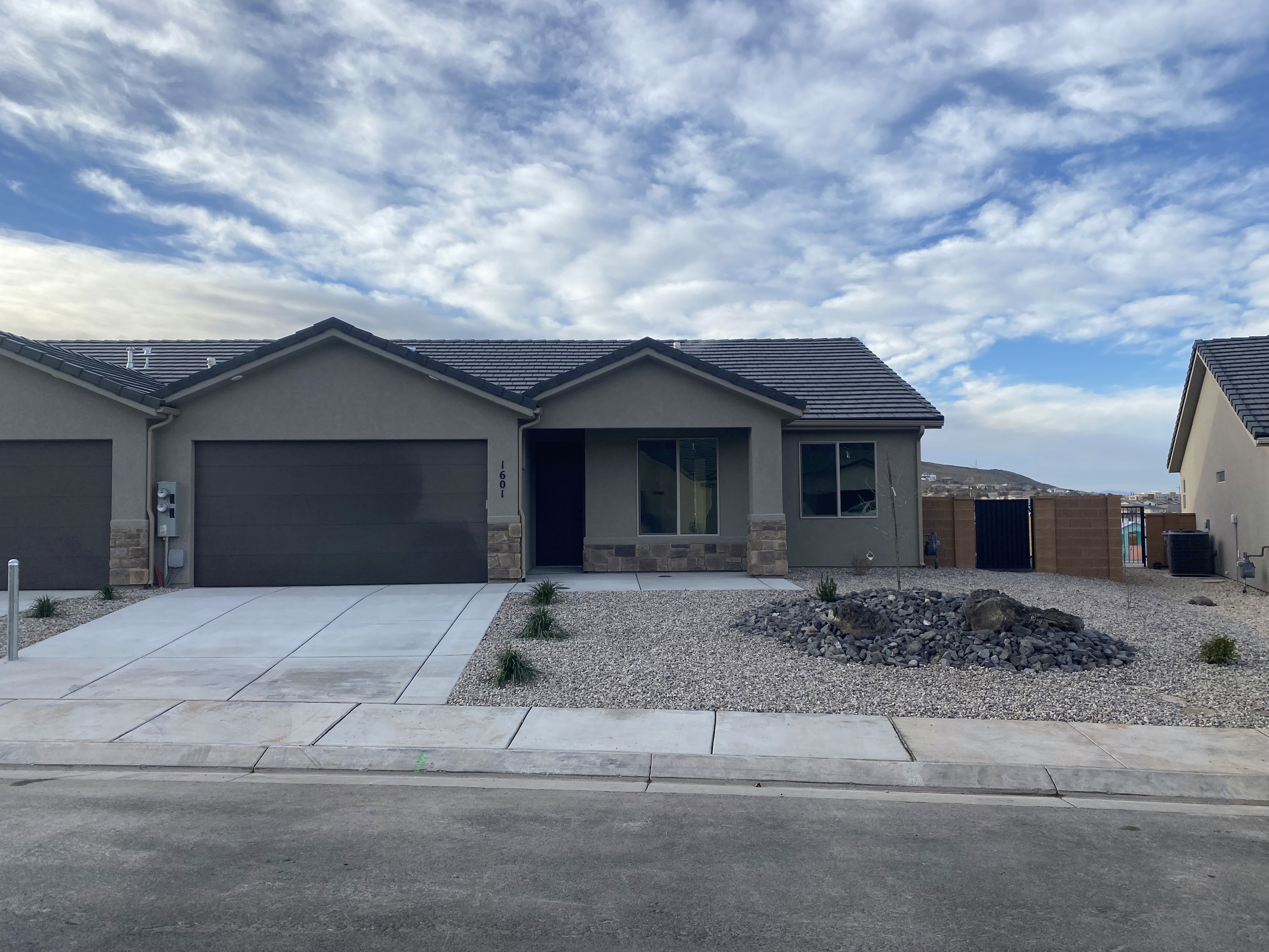 Front exterior perspective of the Golden Hour custom home in Hurricane, Utah highlighting the garage and entry design.