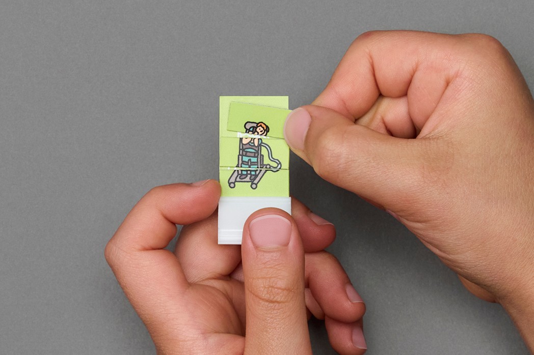 A child in a swimsuit playfully jumps with a water spray in a backyard, surrounded by toys and greenery.