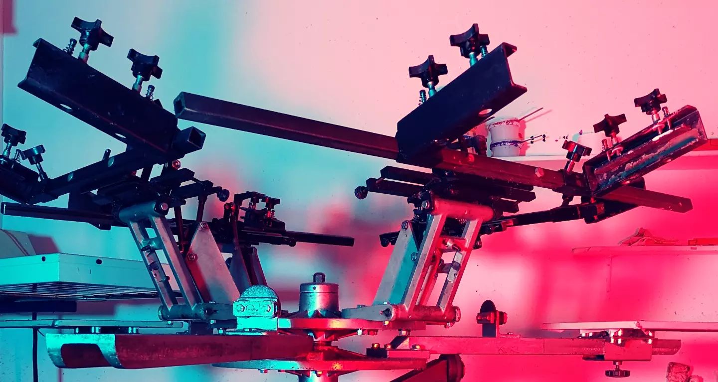 Ein Siebdruckkarussell, welches cyan- und magentafarben angeleuchtet wird