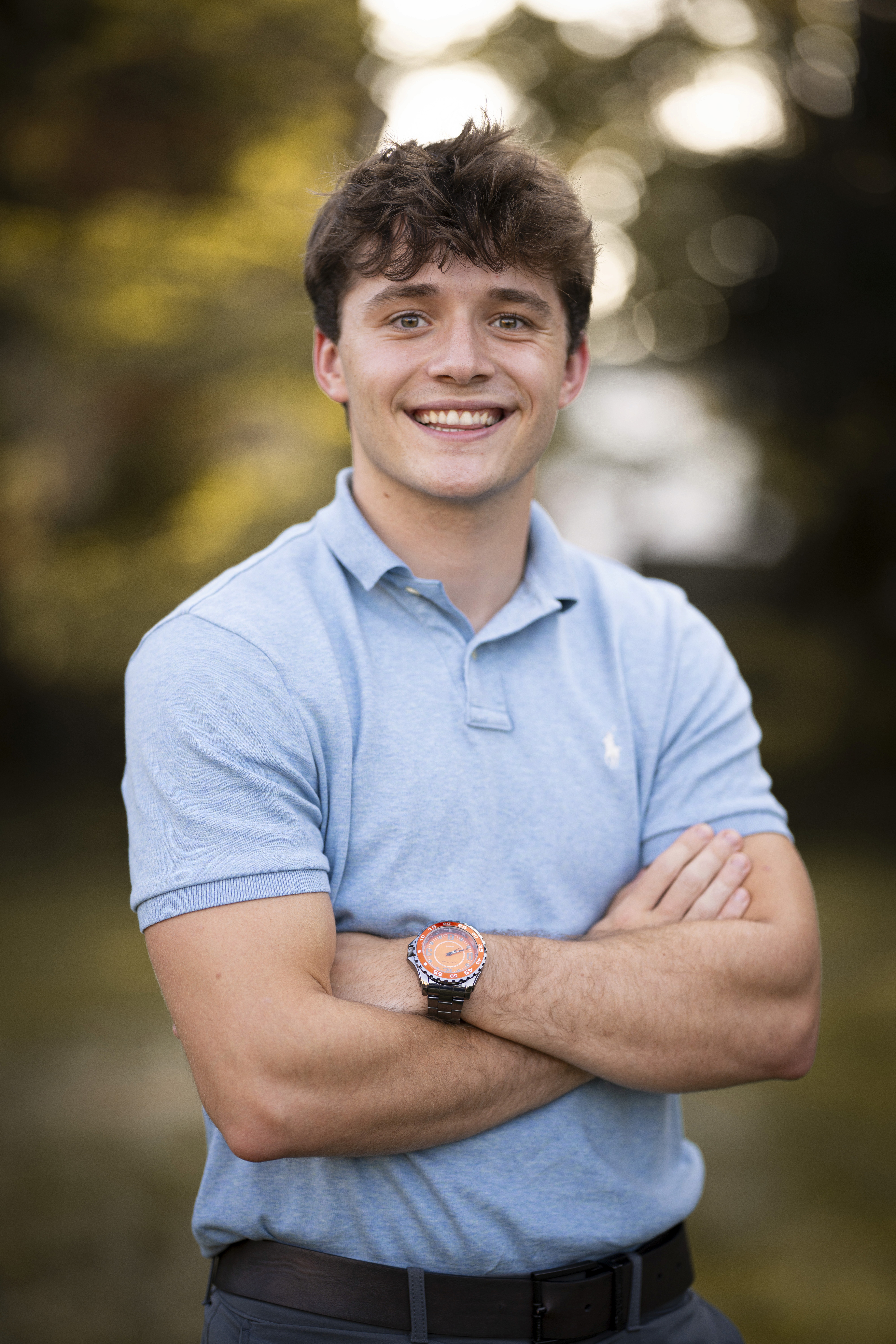 A thoughtful young person with dark hair gazes to the side, captured in soft black and white lighting.