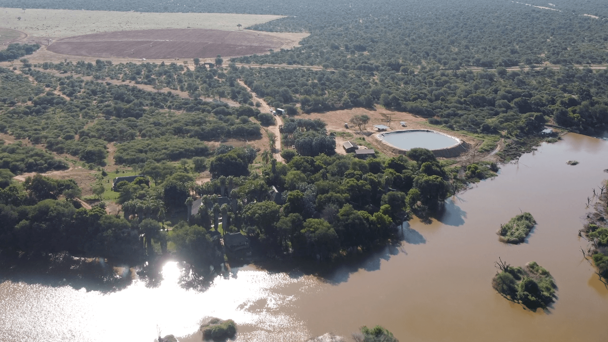 A man and a woman, both in business attire, are engaged in a serious discussion at a table with documents. The setting conveys a professional tone.