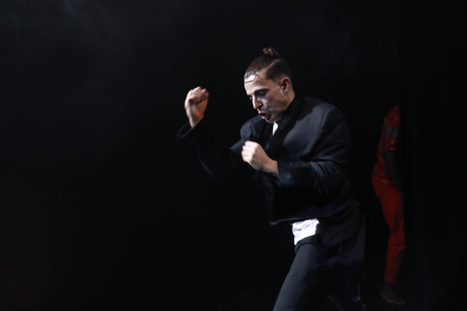 Woman in pink leather jacket crouching outdoors at night