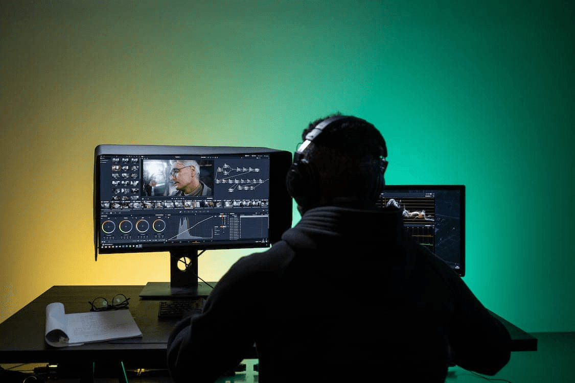 Person editing video on desktop monitors - Best Video Clipping Tool for YouTube